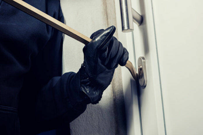 Burglar breaking in to a house door